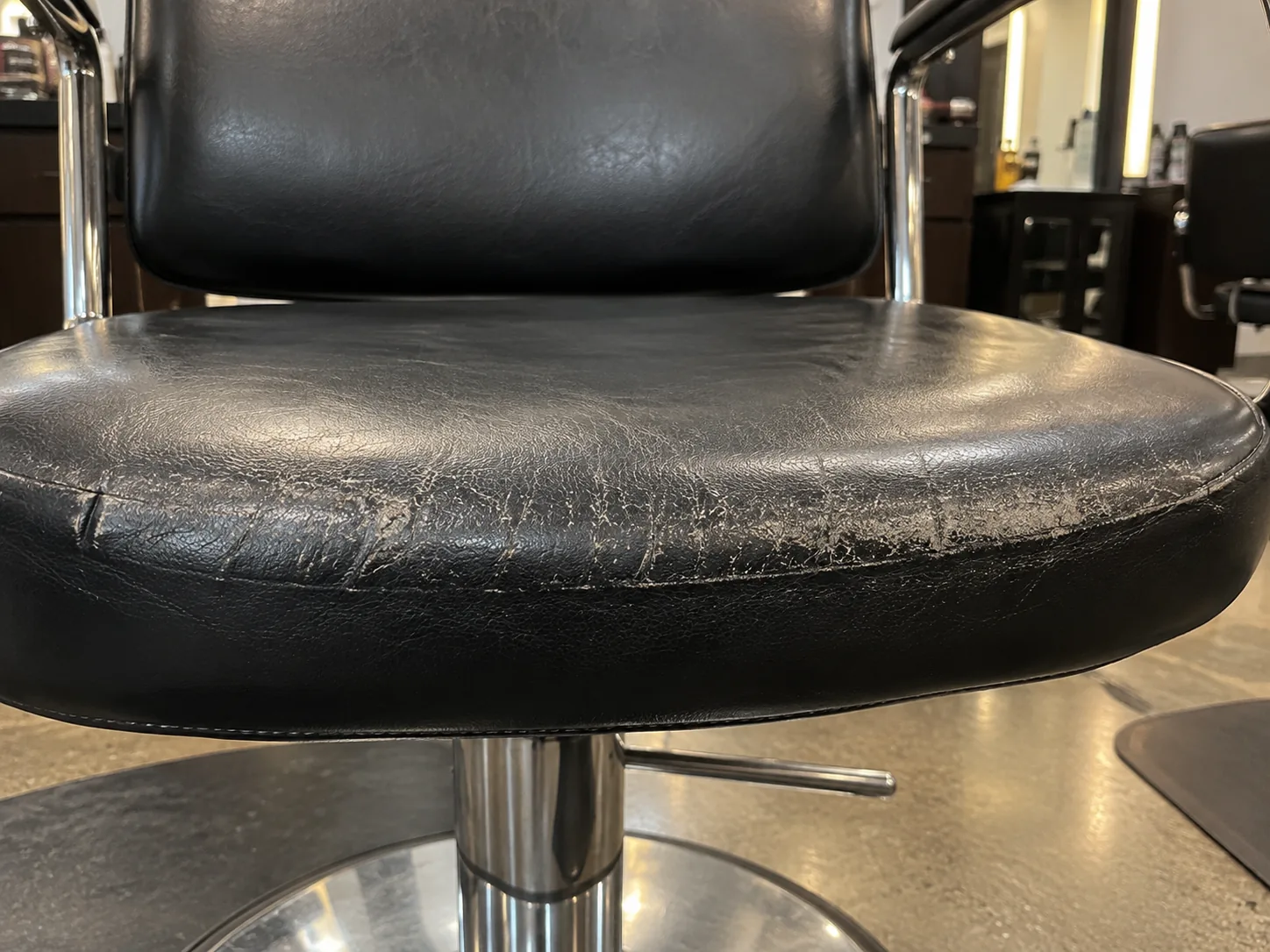 A worn front edge on a styling chair seat