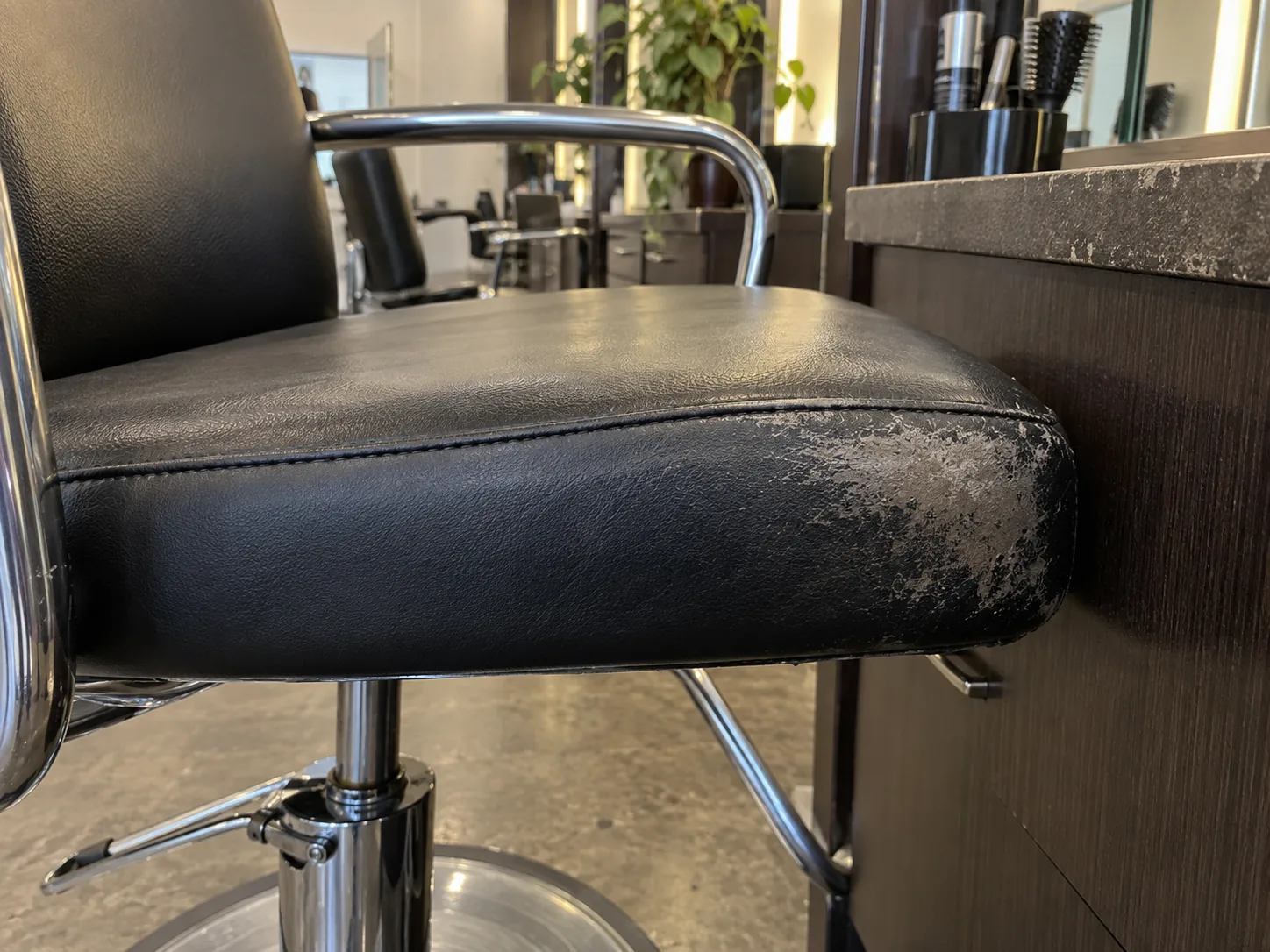 A rubbed side panel on a styling chair seat