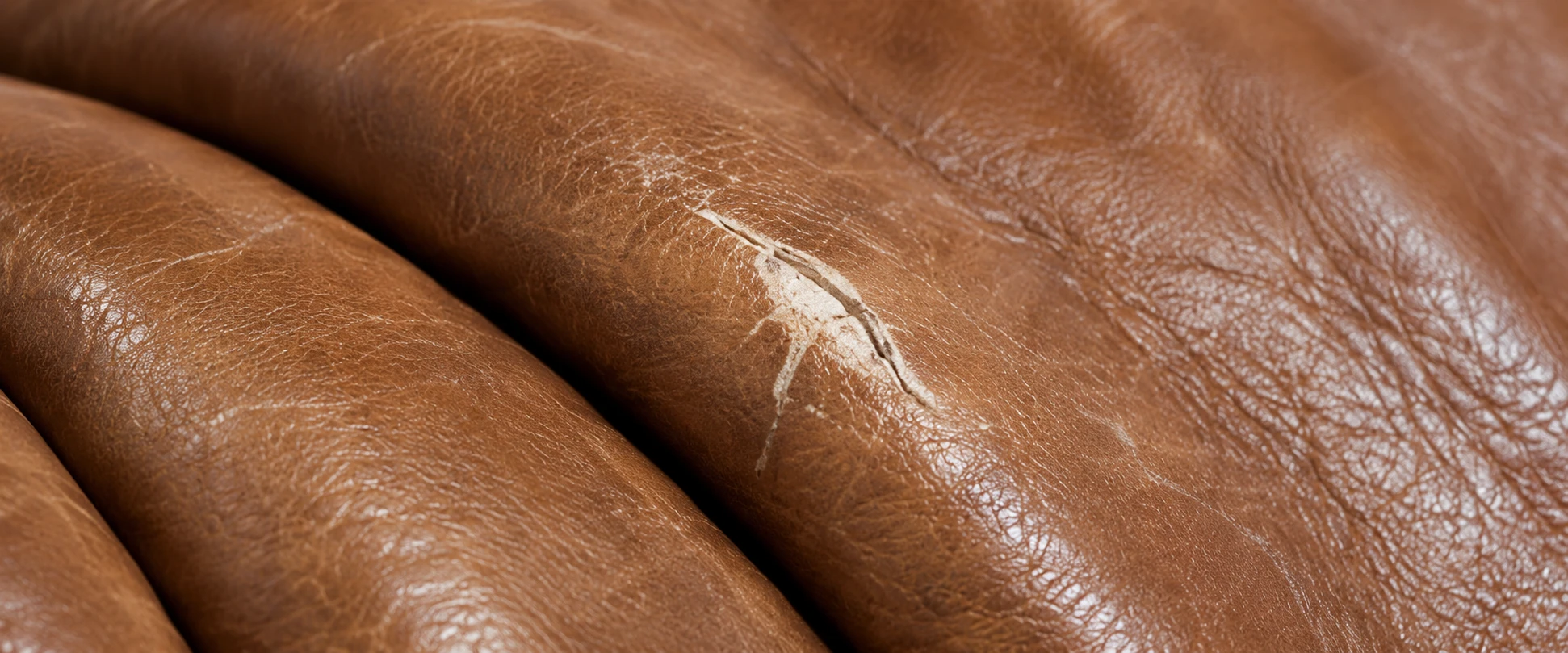 Scuffs and scratches on a tan Togo leather pleat
