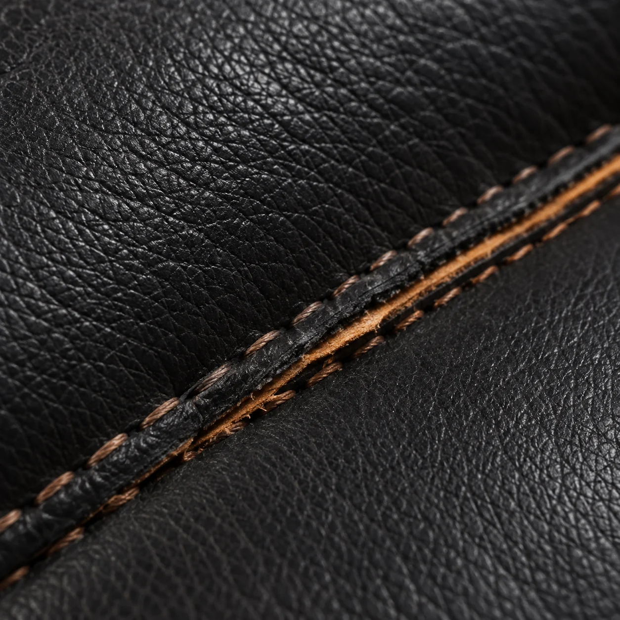 Topstitched theater seat seam opened with the piping cord exposed