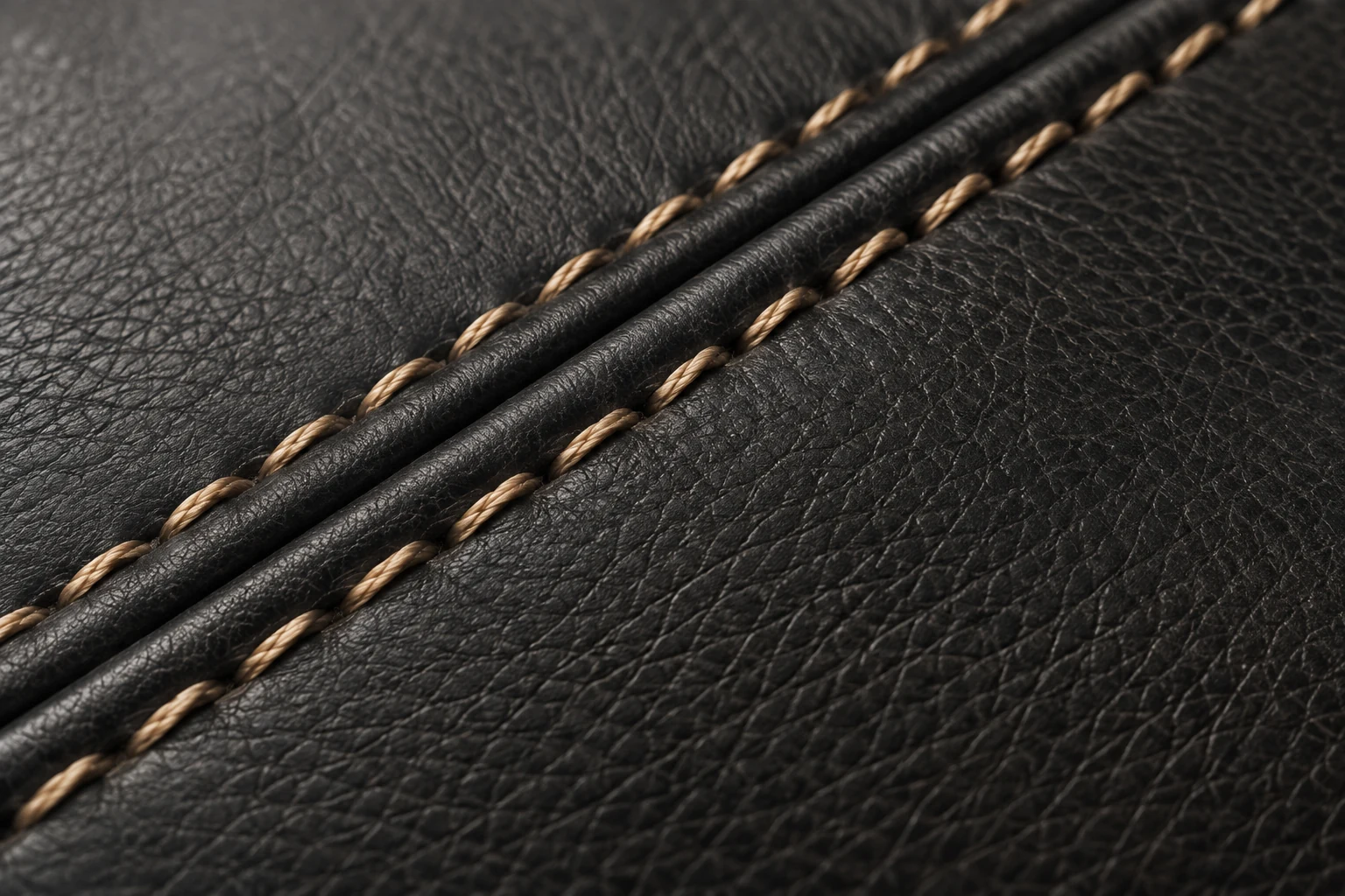 Tan contrast stitching on a black leather seam
