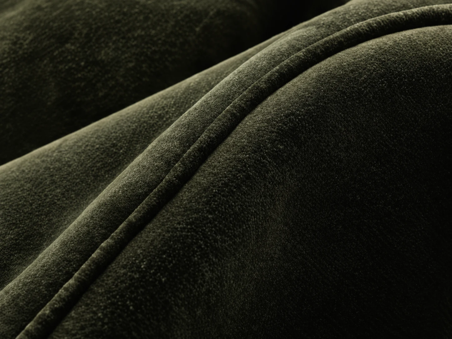 Piped welt seam running along a green velvet arm