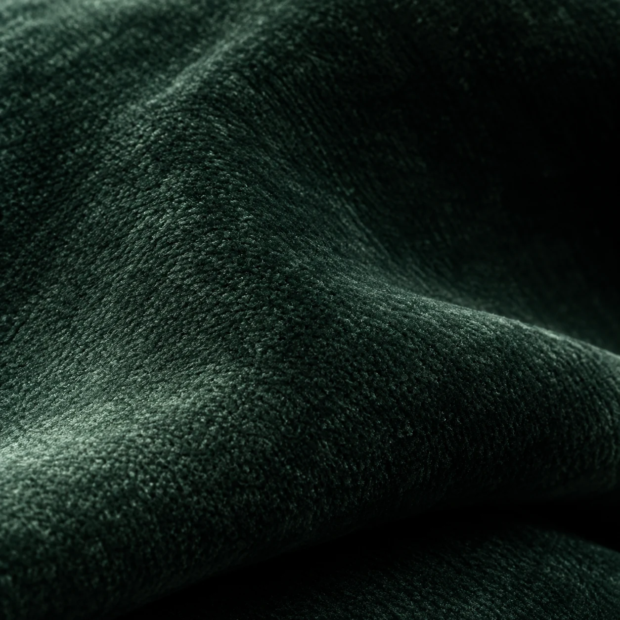 Green upholstery velvet swatch with the pile running to one side
