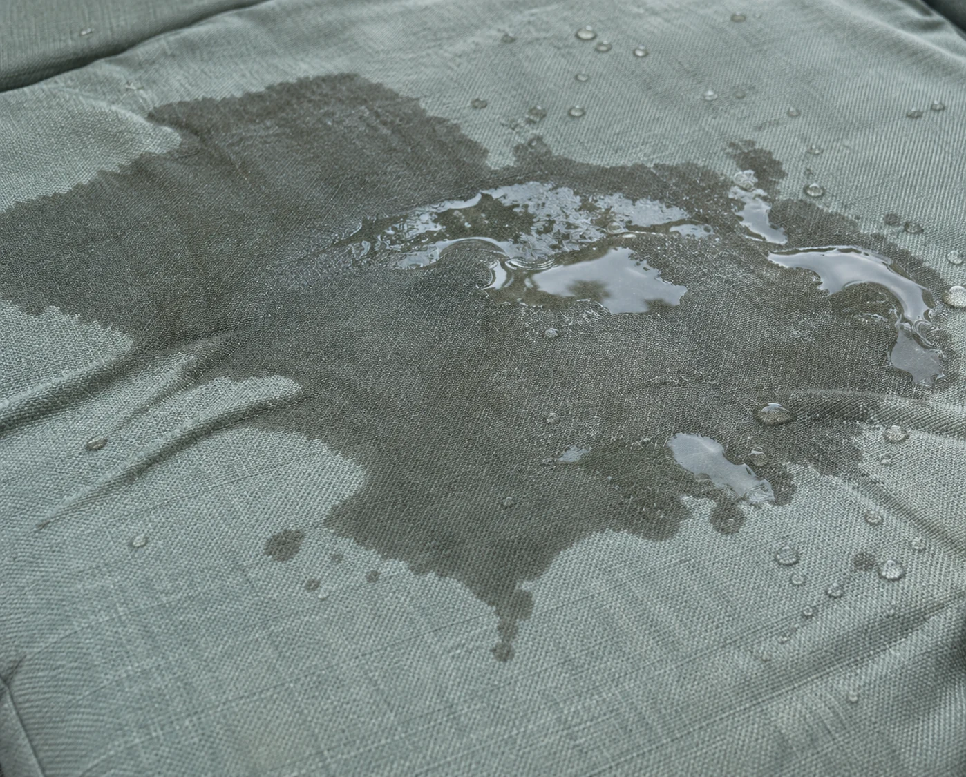 Rainwater pooling on top of a sage outdoor cushion cover instead of draining through