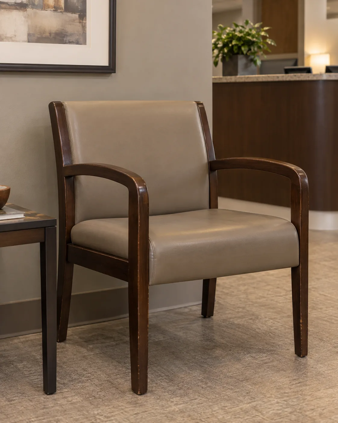 A wood-frame guest chair with a taupe vinyl seat