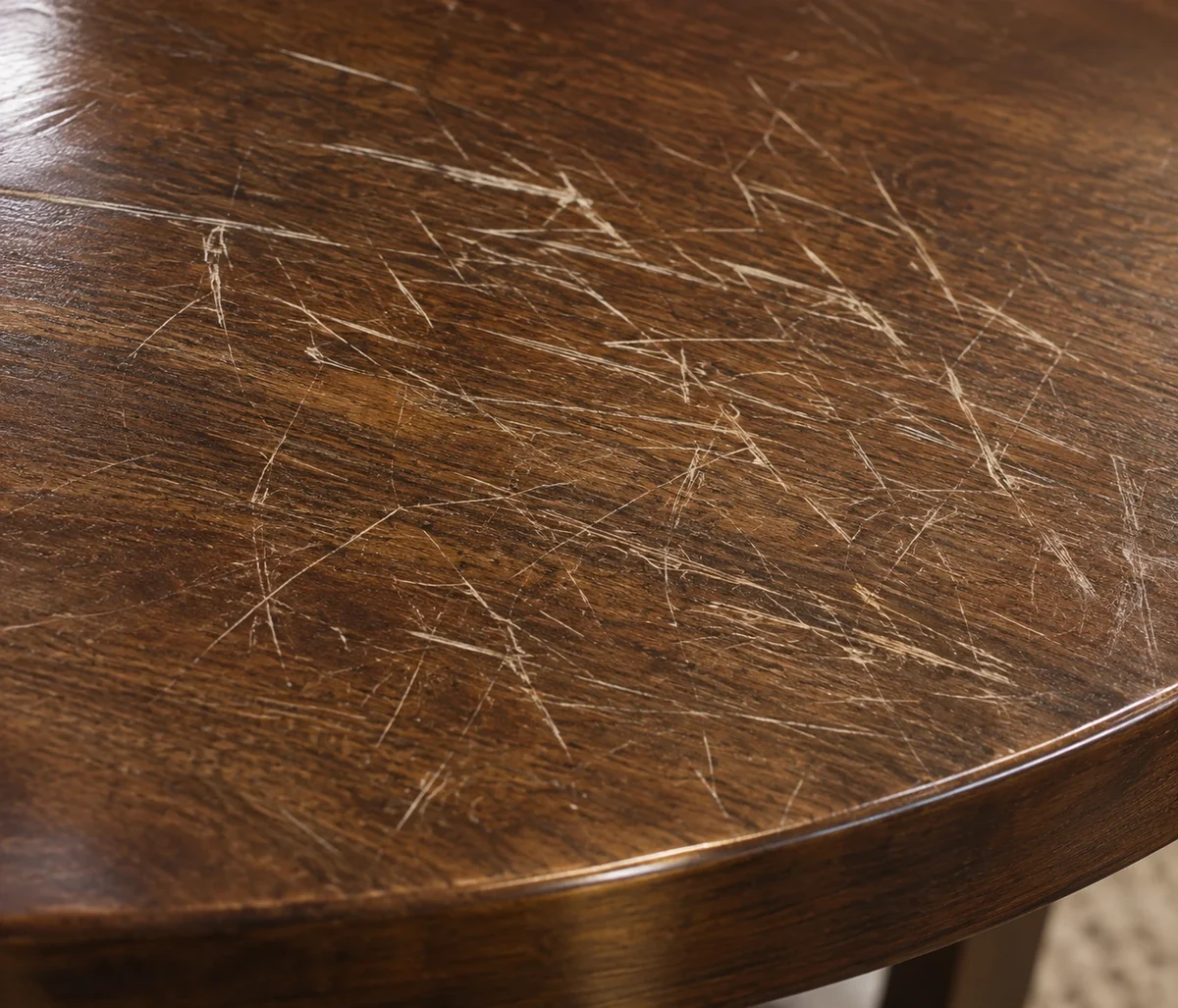 Dining table top covered in fine white surface scratches