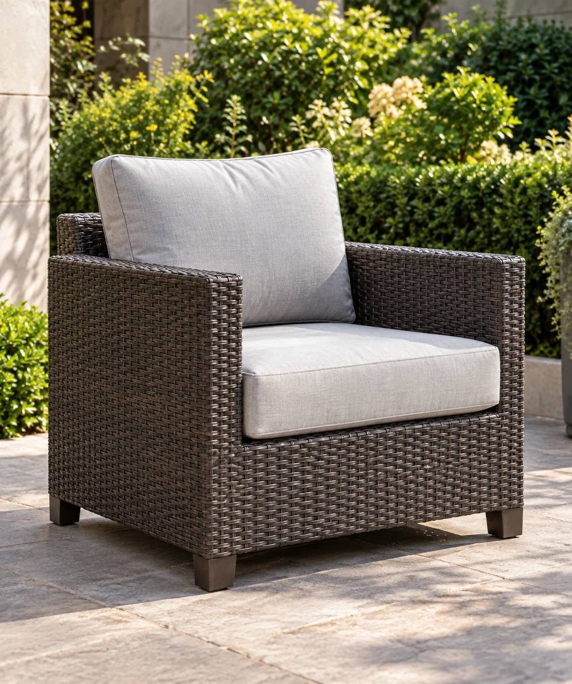 Woven outdoor club chair with grey seat and back cushions