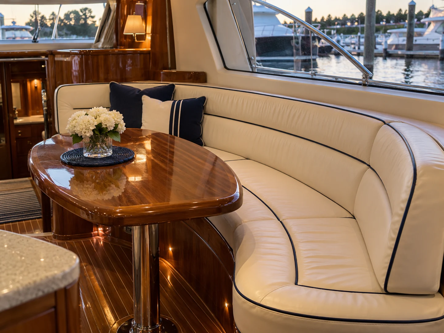 A curved cream settee in a warm teak yacht saloon