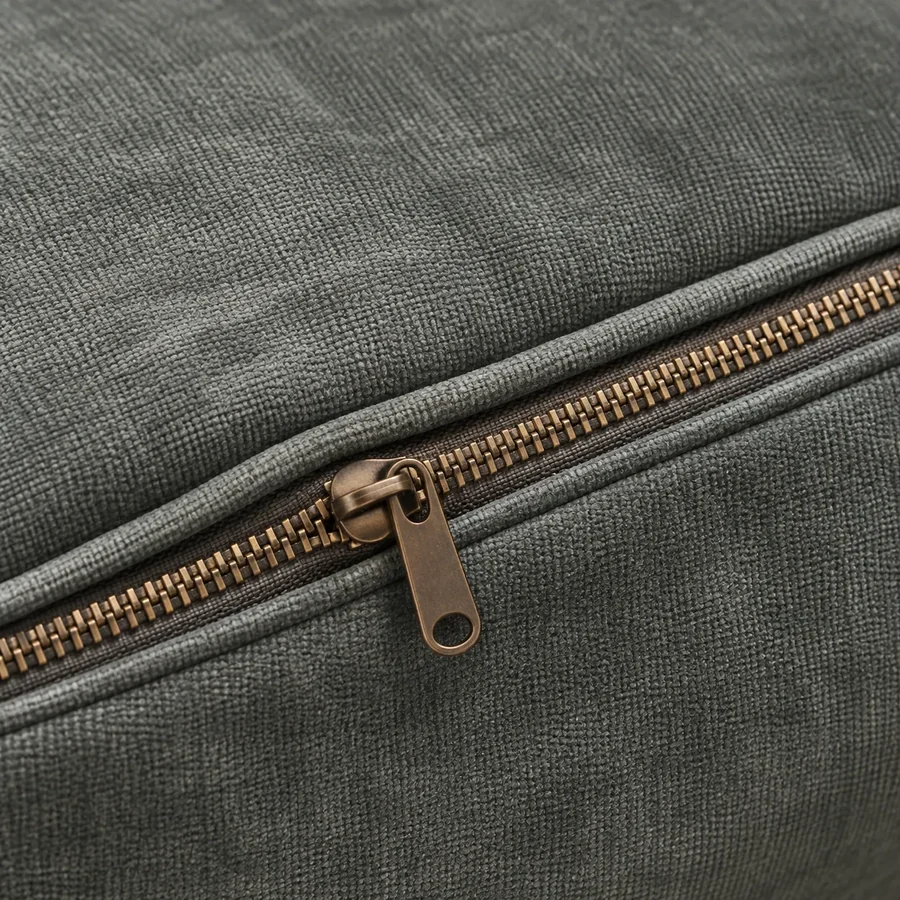 Brass zip running along the seam of a removable cushion cover